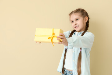 Sticker - Little girl with gift box on beige background. Children's Day celebration