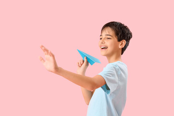 Wall Mural - Little boy with paper plane on pink background. Children's Day celebration