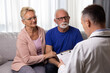 © Space_Cat - Senior couple at doctor medical consultation visit. Healthcare worker discusses health problems with elderly spouses