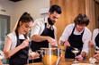 © satura_ - Chef teaching trainees how to make ice cream. Cooking tasty ice cream dessert made from chocolate and vanilla in glass bowl