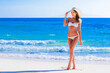 Girl in bikini and sunhat on beach