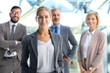 © ty - Business woman with her staff, people group in background at modern bright office indoors.