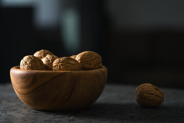 Wall Mural - inshell walnuts in olive wood bowl on terrazzo countertop