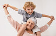 Portrait, airplane and grandmother with child embrace, happy and bonding against wall background. Love, face and senior woman with grandchild having fun playing, piggyback and enjoying game together