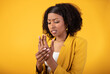 Numbness of the limbs. Black lady suffering from pain in the hand, palm and joints, standing on yellow background