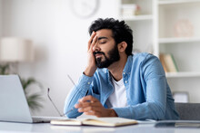 Freelancer Burnout. Tired Indian Man Feeling Sleepy At Workplace In Home Office