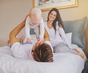 Canvas Print - Happy family, parents and playful baby in bedroom for love, care and quality time to relax together at home. Mother, father and holding infant kid for happiness, support or playing with newborn child