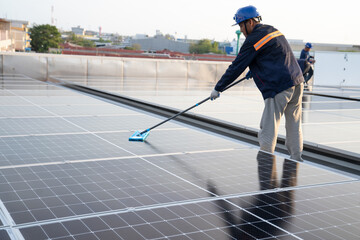 Wall Mural - asian male worker or engineer in solar power plant the solar panel is being cleaned using a mop to c