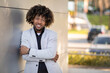 © Prostock-studio - Portrait of black middle aged entrepreneur male with crossed arms posing at camera, leaning on wall near office building