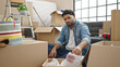 © Krakenimages.com - African american man unpacking cardboard box at new home