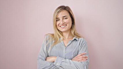 Canvas Print - Young blonde woman smiling confident standing with arms crossed gesture over isolated pink background