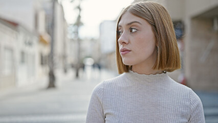 Sticker - Young blonde woman looking to the side with serious expression at street