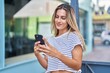 © Krakenimages.com - Young blonde woman smiling confident using smartphone at street