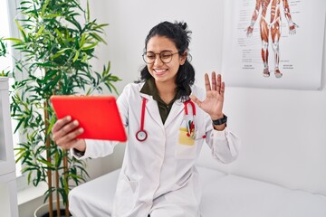 Sticker - Young latin woman wearing doctor uniform having video call at clinic