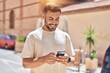 © Krakenimages.com - Young hispanic man smiling confident using smartphone at street