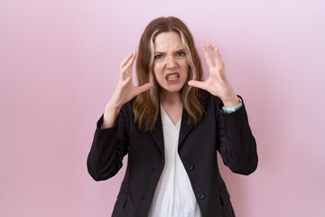 Wall Mural - Young caucasian business woman wearing black jacket shouting frustrated with rage, hands trying to strangle, yelling mad