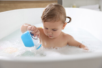 Canvas Print - Cute little girl playing in foamy bath at home