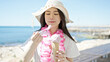 © Krakenimages.com - Young chinese woman tourist smiling confident eating ice cream at seaside