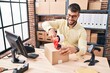 © Krakenimages.com - Young hispanic man ecommerce business worker packing cardboard box at office