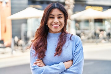 Poster - Young hispanic woman smiling confident standing with arms crossed gesture at street