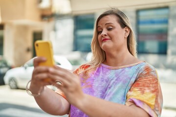 Sticker - Young woman smiling confident using smartphone at street