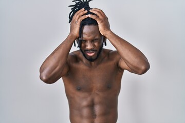 Poster - African man with dreadlocks standing shirtless over isolated background suffering from headache desperate and stressed because pain and migraine. hands on head.