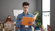 © Krakenimages.com - Young hispanic man preschool teacher reading book with relaxed expression at kindergarten