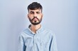 © Krakenimages.com - Young hispanic man with beard standing over blue background looking at the camera blowing a kiss on air being lovely and sexy. love expression.