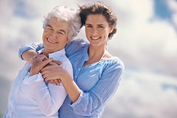 Woman, senior mother and portrait by sky with hug, happiness, love or smile for mothers day on vacation. Elderly lady, daughter or happy with care, bond or outdoor by clouds for holiday in retirement