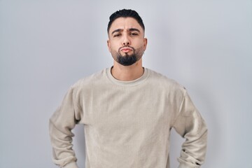 Canvas Print - Young handsome man standing over isolated background looking at the camera blowing a kiss on air being lovely and sexy. love expression.