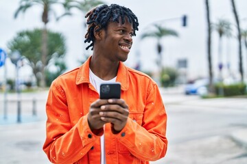 Poster - African american man smiling confident using smartphone at street