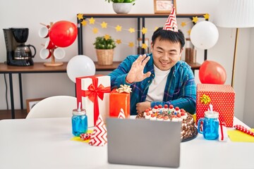 Sticker - Young chinese man celebrating birthday with cake doing video call looking positive and happy standing and smiling with a confident smile showing teeth