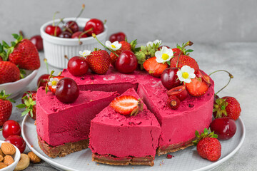 Wall Mural - Sliced raw vegan berry cashew cake with fresh strawberry and cherry. Healthy veggie food