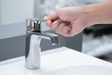 Save Water Concept. Hand Closing Stainless Steel Water Tap Or Chrome Faucet In The Bathroom.