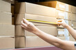 Male worker hands using tape measure on carton box in warehouse. Checking dimensions for goods delivery. Logistics service and cargo shipping business concepts