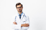 Fototapeta Na drzwi - Man portrait of a doctor wearing a white coat and eyeglasses and a stethoscope looking into the camera on a white isolated background, copy space, space for text, health