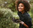 © Mapodile M/peopleimages.com - Black woman in garden, plant and smile in portrait, botany mockup and environment with young gardener and flowers. Happy female person is outdoor with green fingers, growth and plants with gardening