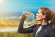 © Katleho Seisa/peopleimages.com - Woman drinking water, health and fitness in nature, blue sky and athlete outdoor with hydration and mockup space. Exercise at beach, female person drink h2o in bottle, workout and break from training
