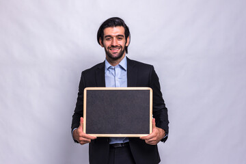 Poster - Businessman holding chalk board on white background. Handsome businessman holding black board. Handsome man holding small framed blackboard