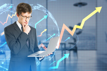 Aufkleber - Attractive young european businessman using laptop with growing arrows and globe on blurry office interior background. Growth, success and money concept. Double exposure.