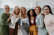 © gstockstudio - Multi-ethnic group of confident mature women embracing and smiling at camera