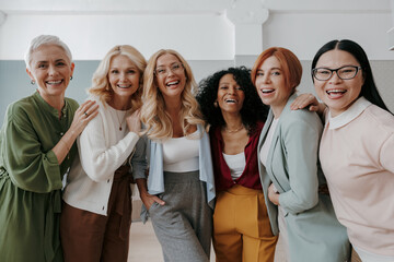 Wall Mural - Multi-ethnic group of confident mature women embracing and smiling at camera