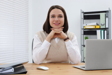 Canvas Print - Happy young intern working at table in modern office