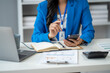 © PaeGAG - Close up view of businesswoman using smartphone in the office room.