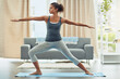 © Nola V/peopleimages.com - Yoga, pilates and woman stretching in home for wellness, workout and fitness in living room. Healthy body, warrior pose and female person doing exercise for balance, flexibility and wellbeing on mat