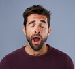 © Ruan J/peopleimages.com - Tired, yawn and man in studio for fatigue or low energy against a grey background. Exhausted, yawning and face of bored male sleepy, lazy or suffering from insomnia, problem or burnout with emoji