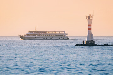 Canvas Print - Ferry boat ship and radio lighthouse at sunset time in Izmir, Turkey