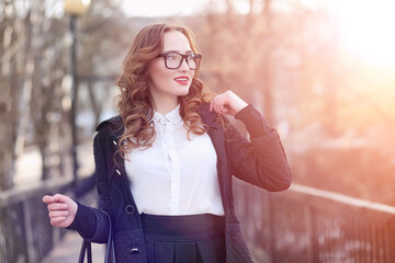 Girl business woman in the spring on a walk in a coat