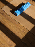 Fototapeta  - Image of corkwood yoga mat on the floor of a bright sunny studio with copyspace