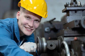 Close up caucasian man engineering workers wear yellow hard hat working machine lathe metal in factory industrial. mechanical operator male worker. Heavy industry concept.